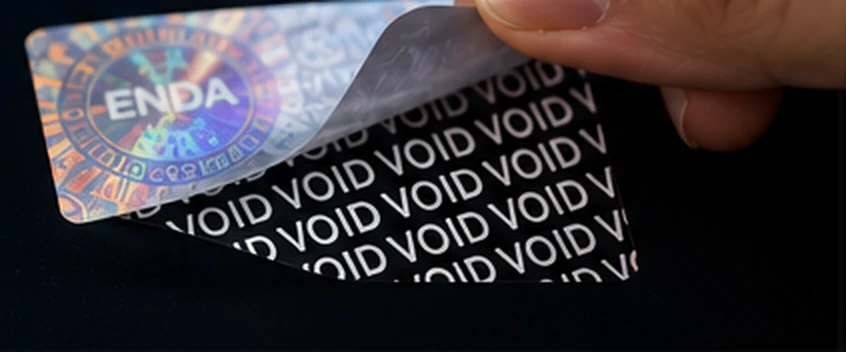 Tamper-evident security label peeled back to show a VOID pattern